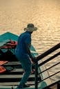 Man with Hat in Blue Polo Shirt Standing on Boat