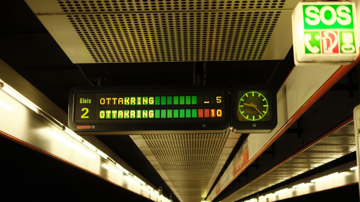 Digital display board at a Vienna subway platform showing train schedules and times.