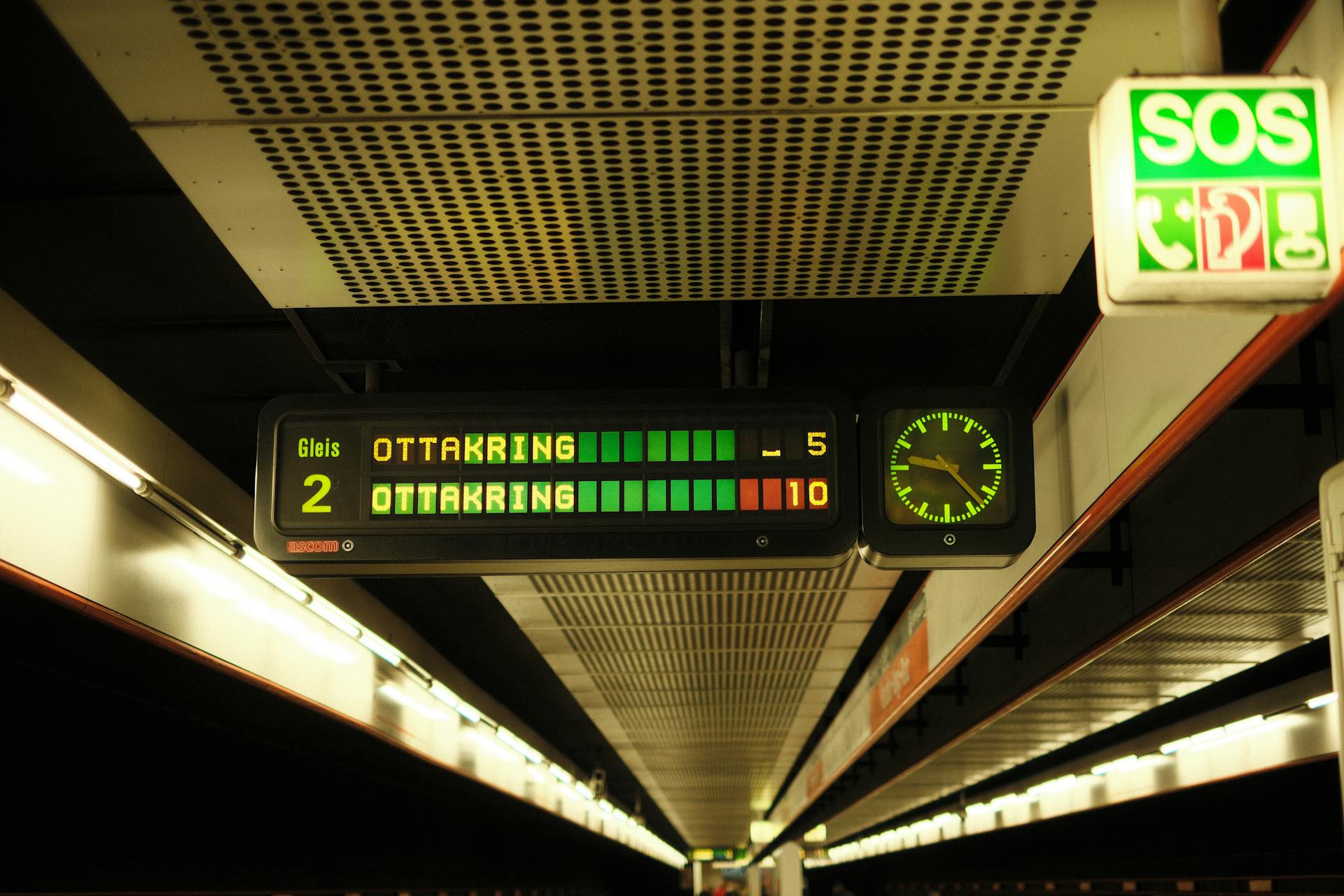 Digital display board at a Vienna subway platform showing train schedules and times.