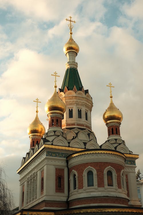 Traditional Church with Golden Domes against Cloudy Sky
