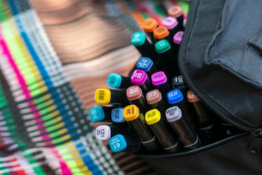 Vibrant markers arranged in a case on a colorful striped tablecloth.