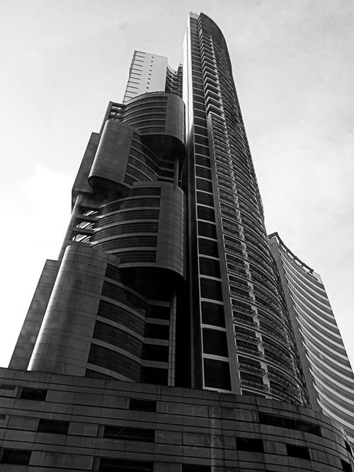 Free Stunning black and white shot of a modern skyscraper with unique architectural design in an urban setting. Stock Photo