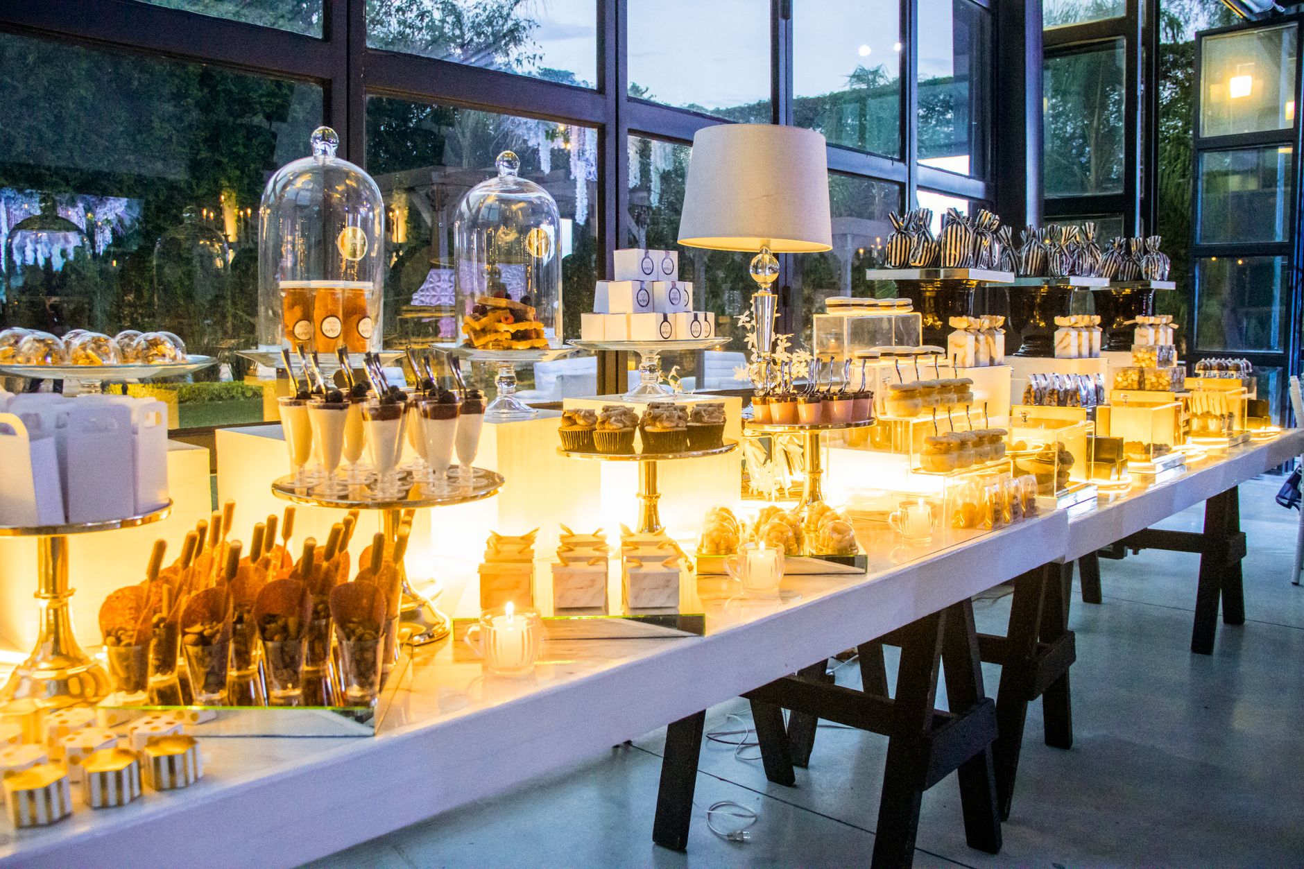 A lavish indoor dessert buffet setup with various sweet treats elegantly styled.