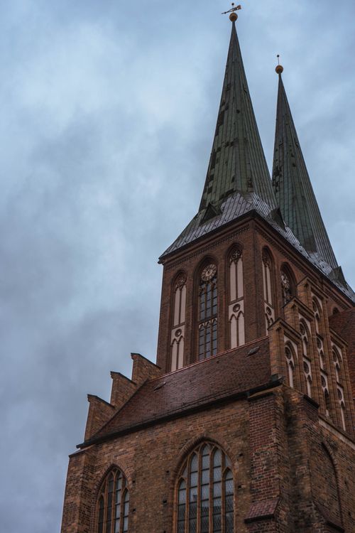 Free Majestic spires of St Nicholas Church against a dramatic cloudy sky in Berlin, Germany. Stock Photo