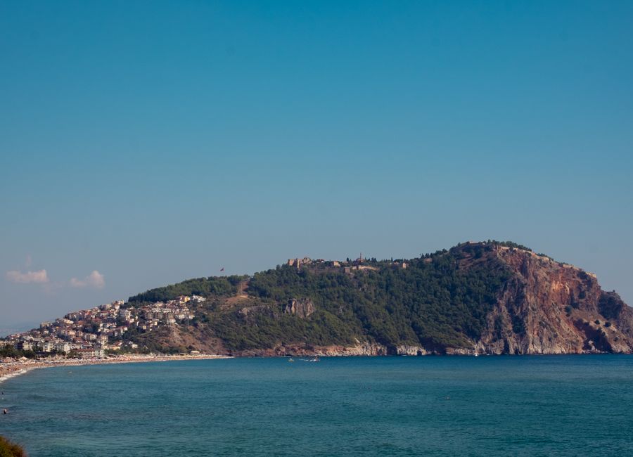 A breathtaking view of the Alanya Peninsula with clear blue skies and turquoise waters.