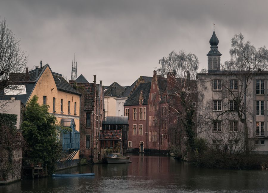 Atmospheric view of a historic canal and old town architecture in Ghent, Belgium.