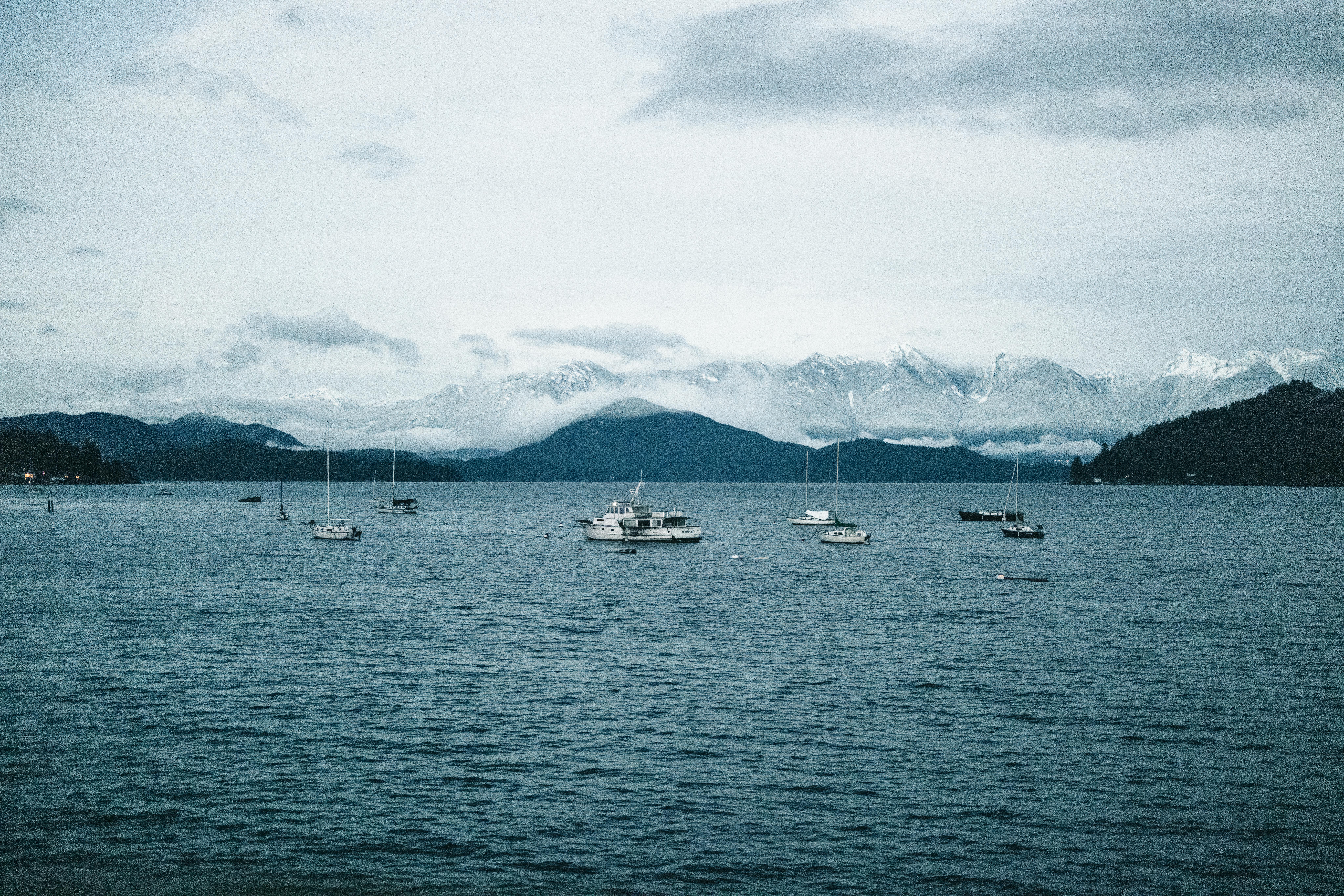 Scenic view of boats on Gibsons harbor with snow-capped mountains in British Columbia.