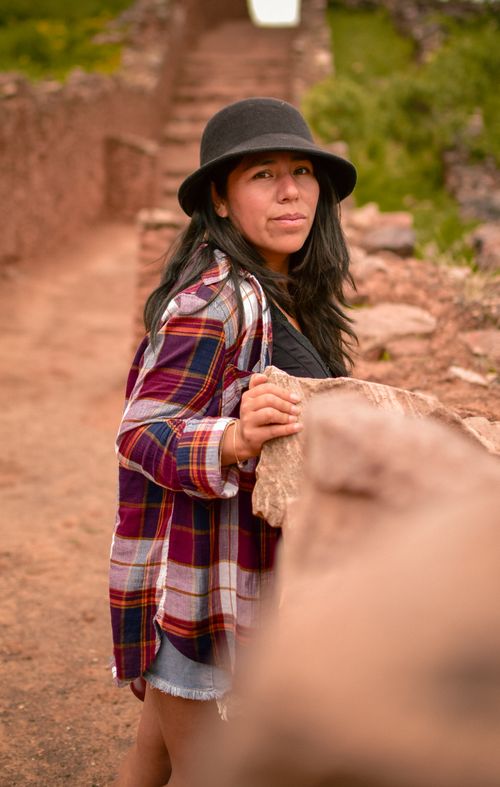 Free Confident woman in hat and plaid shirt standing outdoors on a rustic path. Stock Photo