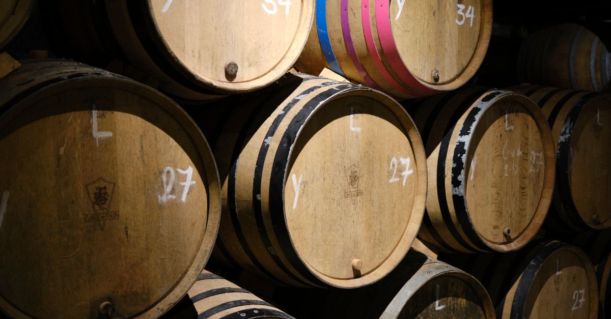 Close-up of stacked wooden wine barrels in a Brussels wine cellar, showcasing wine production and storage.