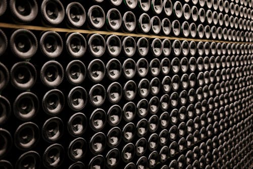 Close-up of Wine Bottles Lying in Rows in a Wine Cellar 