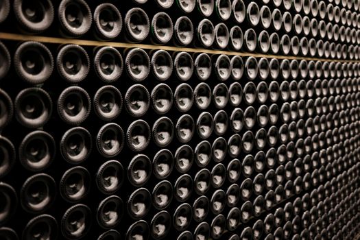 A close-up view of wine bottles stacked symmetrically in a wine cellar in Brussels, Belgium.