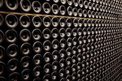 Free A close-up view of wine bottles stacked symmetrically in a wine cellar in Brussels, Belgium. Stock Photo