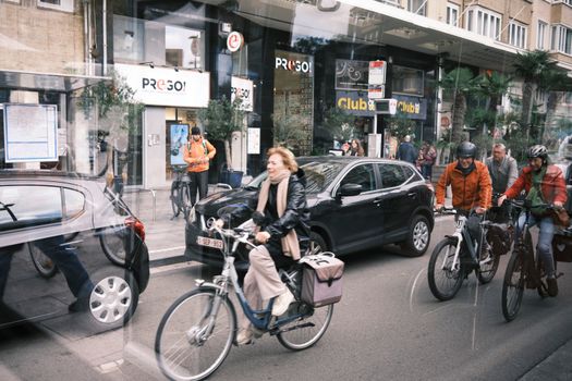 Cyclists and pedestrians navigate the busy urban streets of Brussels, capturing the city's vibrant pace.