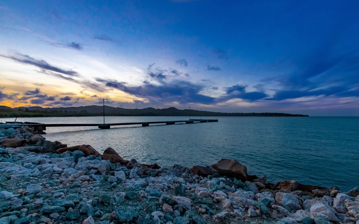 Dramatic evening sky over a rocky shoreline and pier in Puerto Plata, Dominican