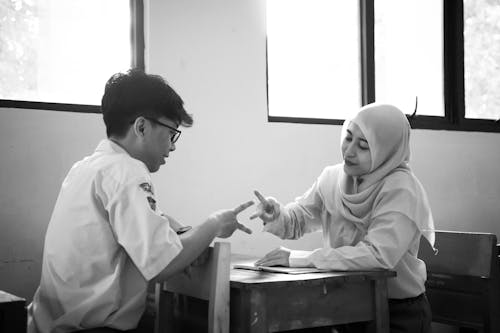 Students at School Desks Playing Rock Paper Scissors