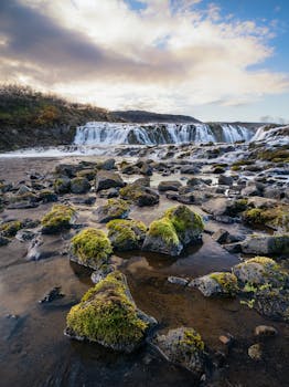 Explore Bruarfoss waterfall in Iceland with its mossy rocks and cascading waters, a perfect travel destination.