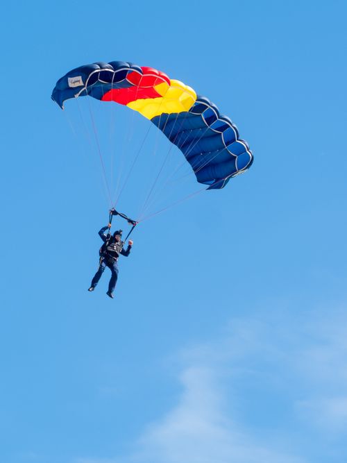 Free Experience the thrill of paragliding under a vibrant blue sky in East Sussex, England. Stock Photo