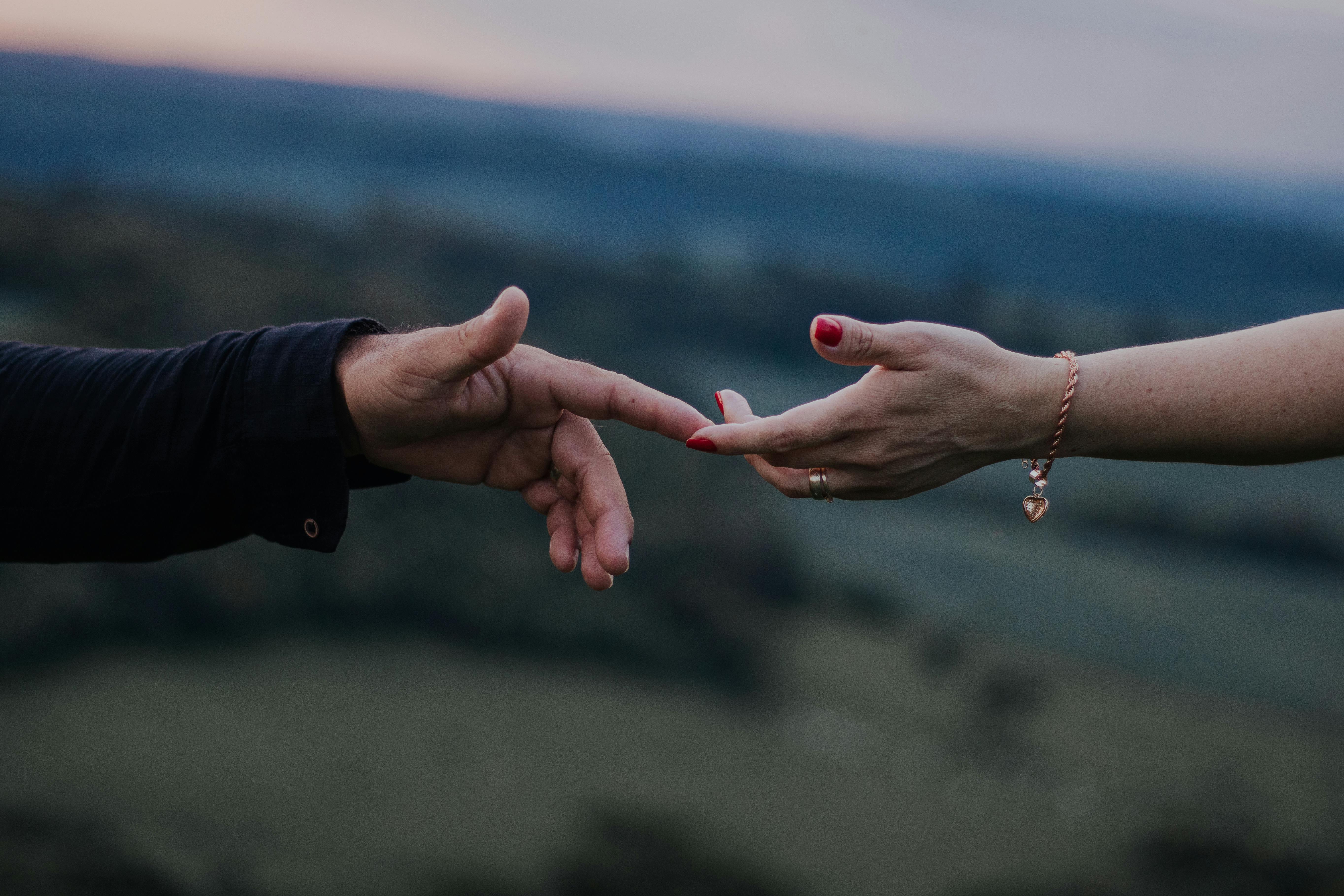 Close-up of couple's hands tenderly touching, evoking sensual intimacy and connection in soft twilight