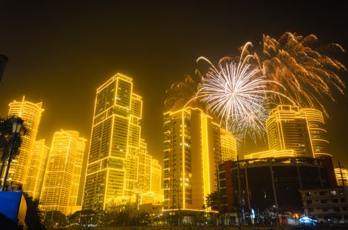 Free Bright fireworks illuminate a city's skyline at night, celebrating an event with dazzling lights. Stock Photo
