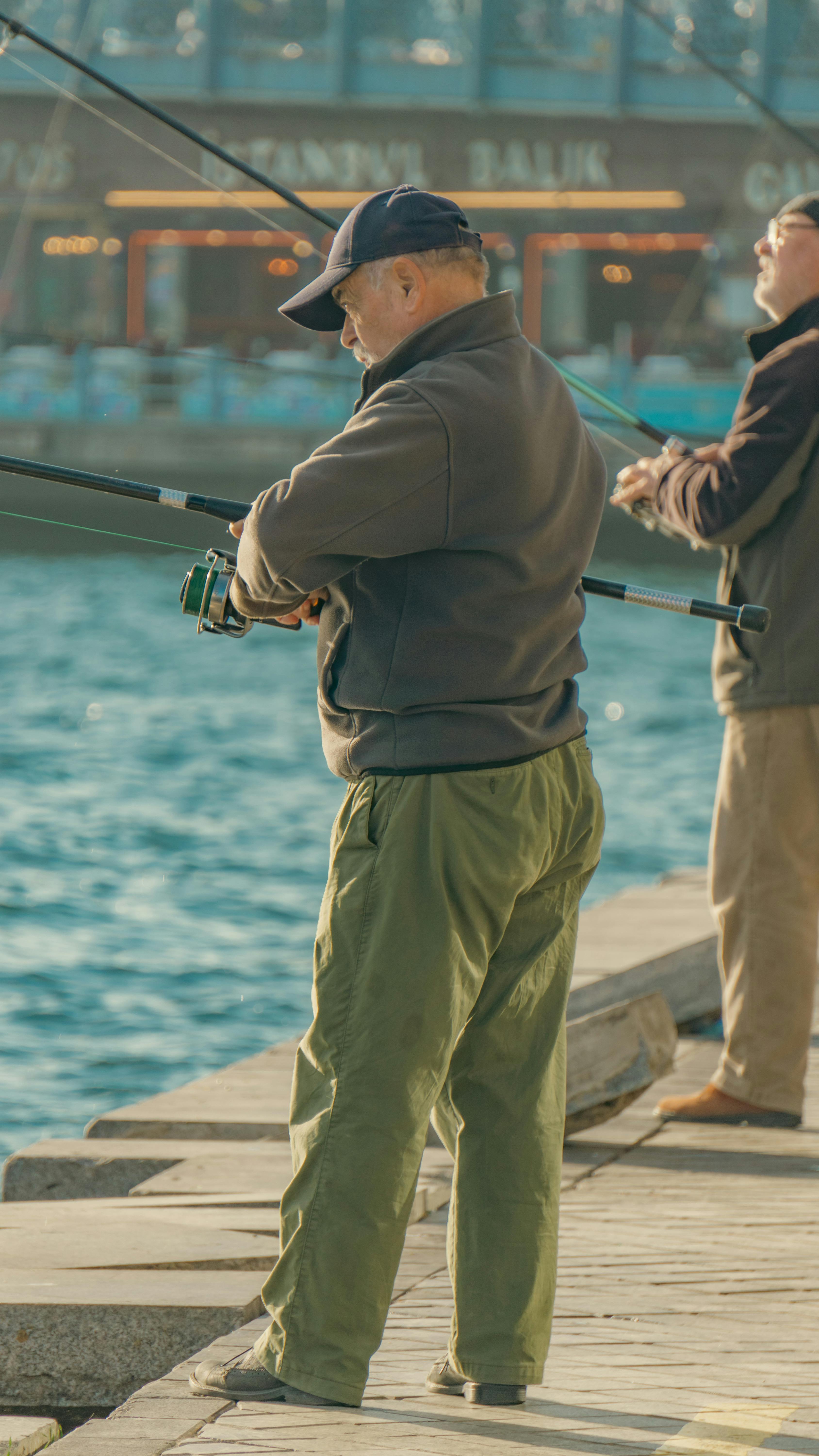 Two Men Standing on Concrete Dock Fishing on Sea · Free Stock Photo