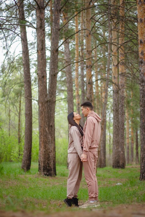 A Couple Standing in a Forest and Holding Hands 