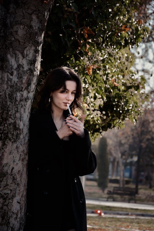 Woman Smoking a Cigarette in a Park