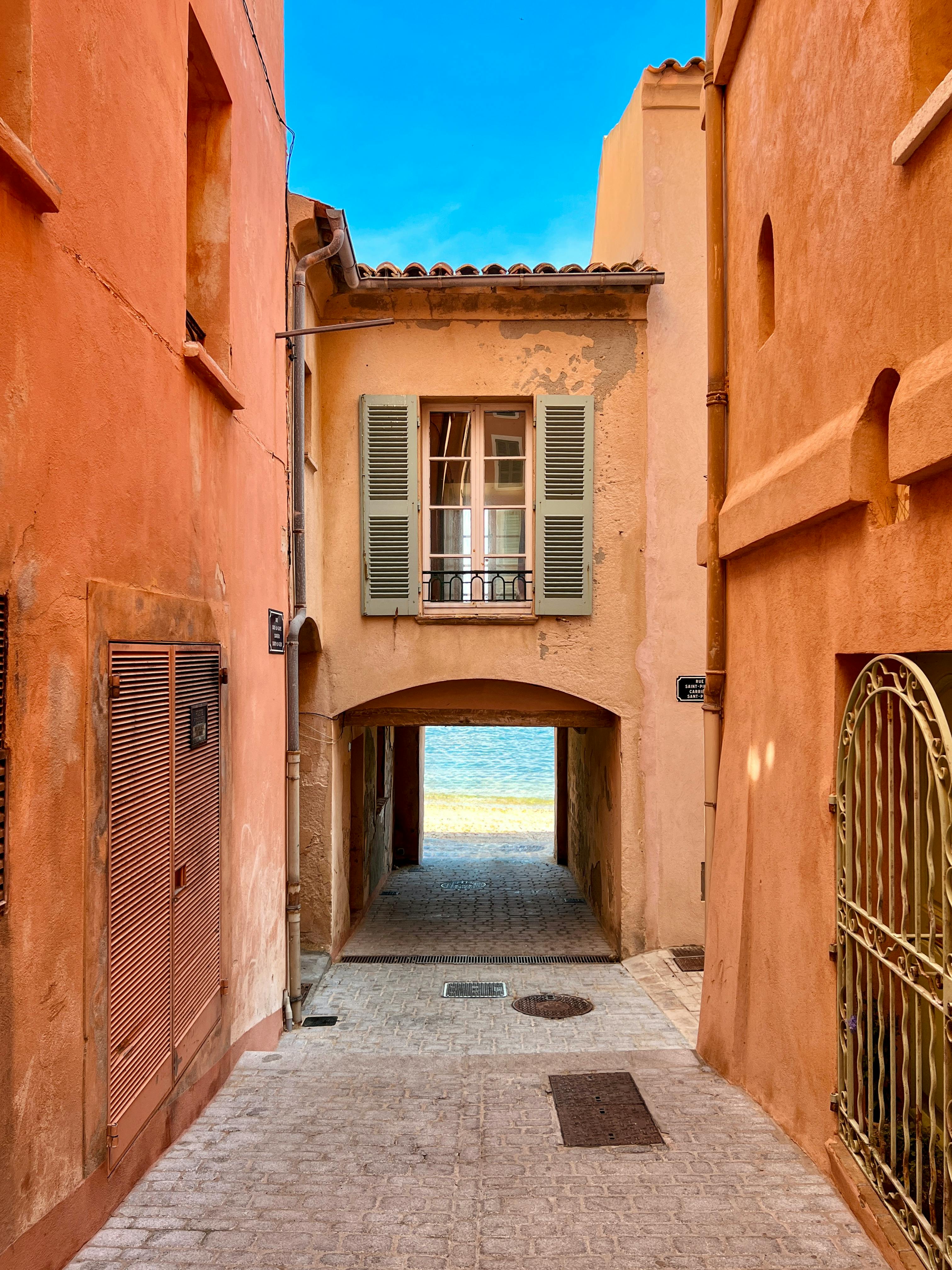 Captivating alleyway in Saint-Tropez, France, revealing a view of the sea.