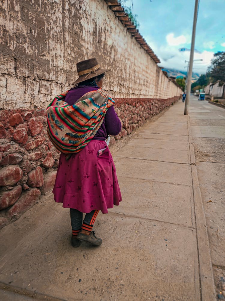 Elderly Woman In Blouse And Skirt Walking With Bag On Sidewalk