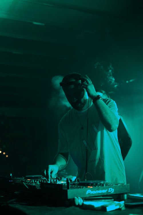 Free DJ passionately mixing tracks in a vibrant Samsun nightclub, creating an electrifying party atmosphere. Stock Photo