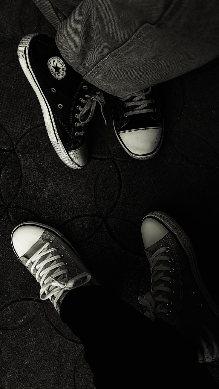 Stylish black and white top view of sneakers on patterned floor.
