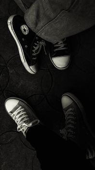 Stylish black and white top view of sneakers on patterned floor.