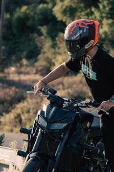 Motorcyclist with helmet adjusting the bike for an outdoor adventure on a sunny day.