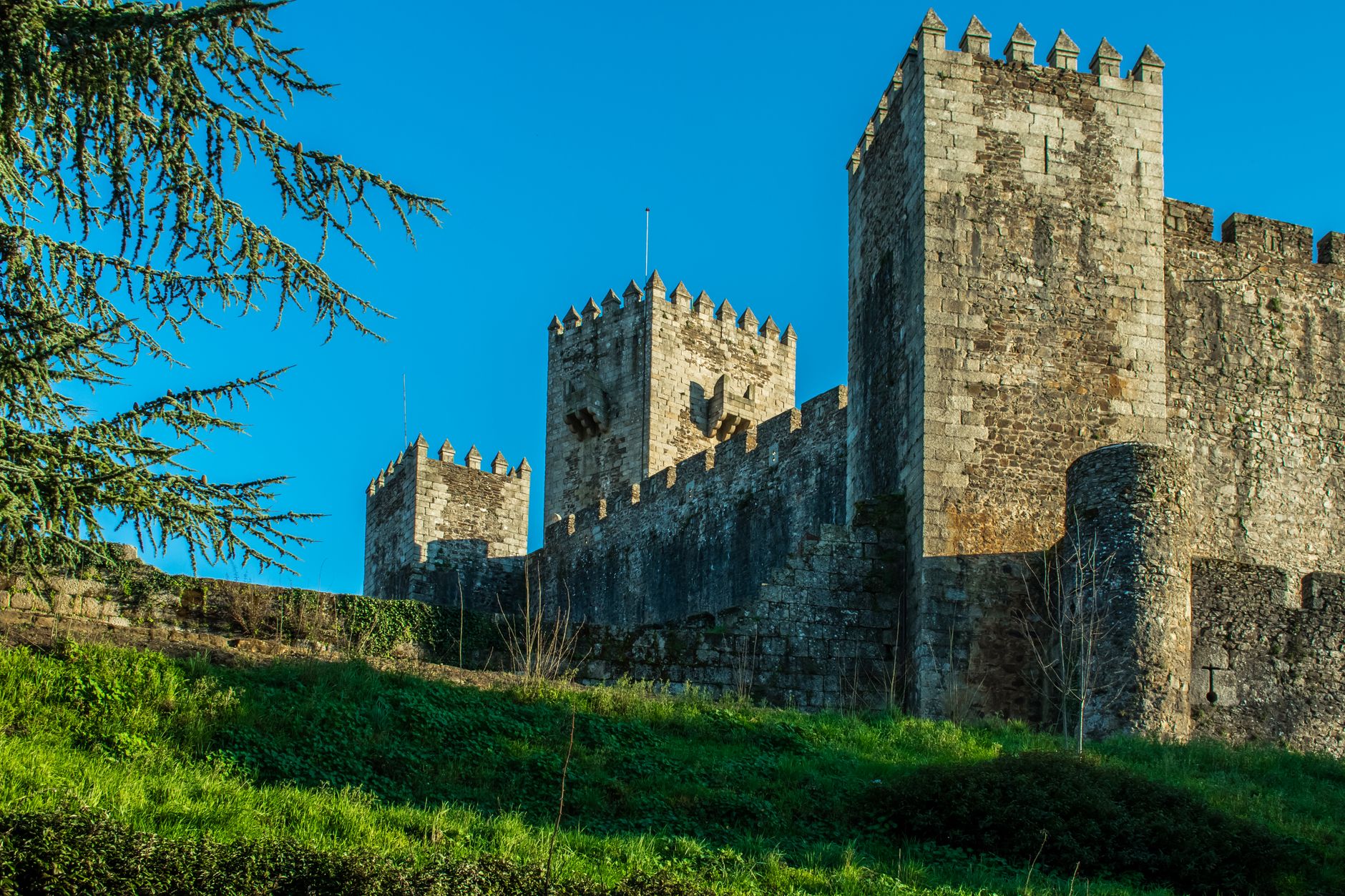 Explore the majestic medieval towers of Sabugal Castle in Portugal under a clear blue sky.