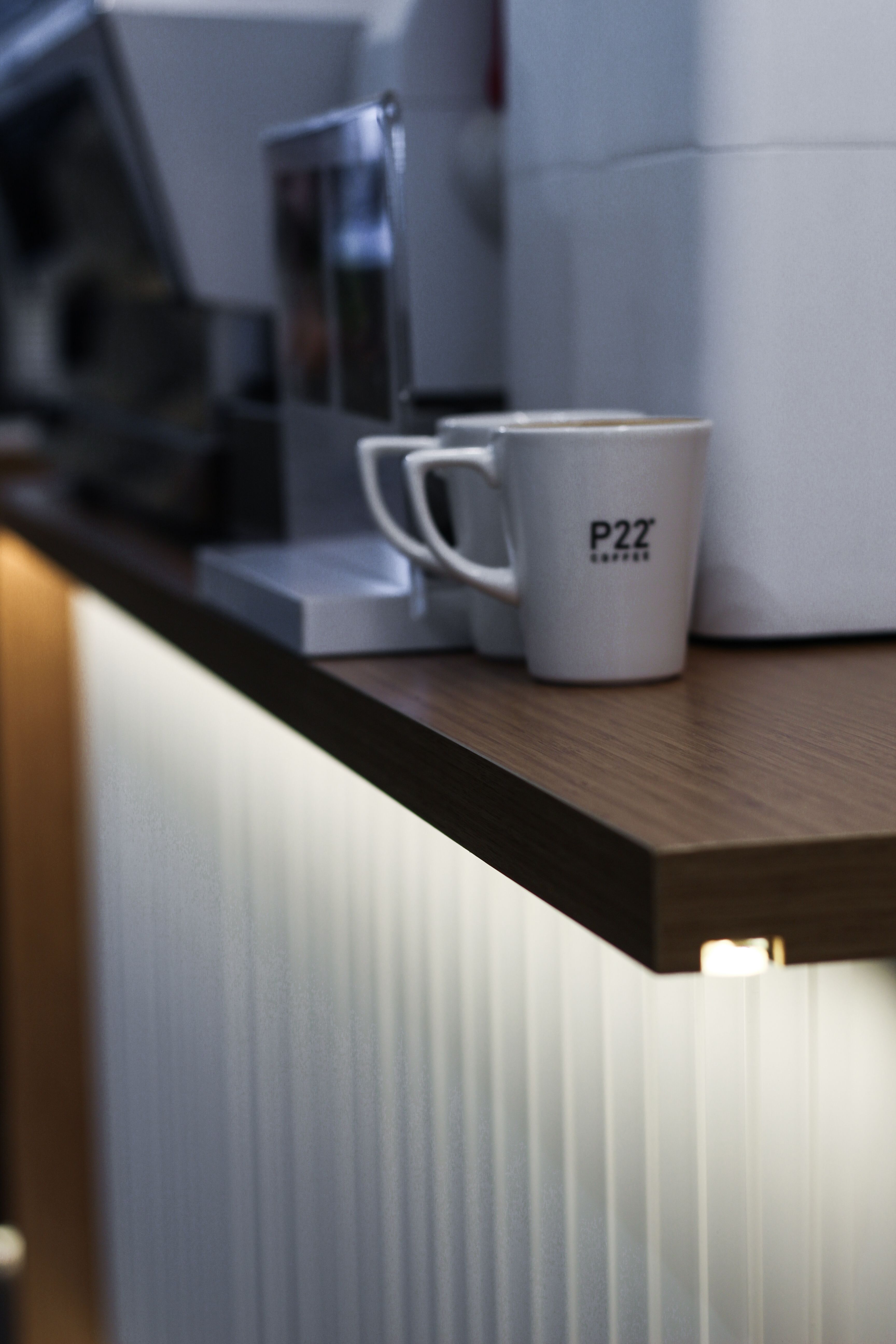 Motion sensor LED under-counter lights illuminating a small apartment coffee bar at night