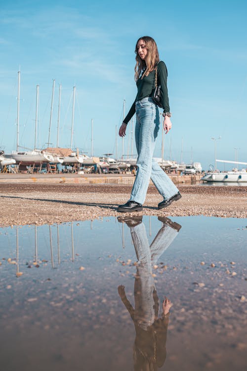 Woman Walking near Puddle on Beach