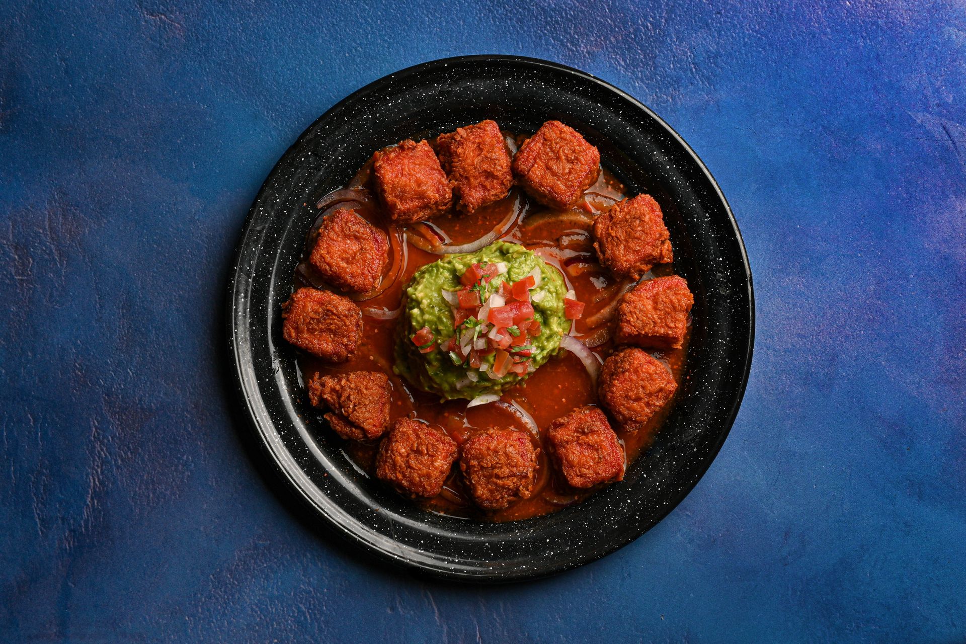 Mexican Meatballs on a Black Plate with a Blue Background