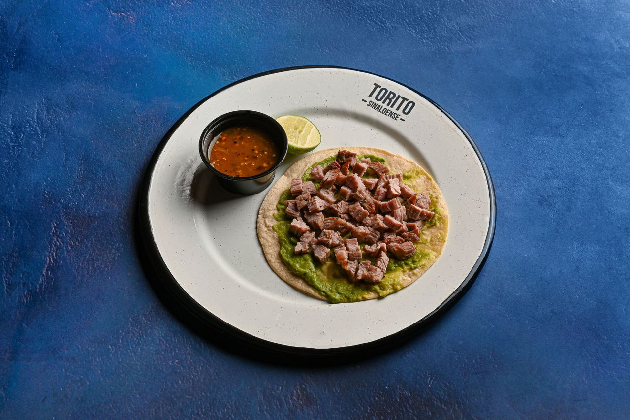 Mexican beef taco served with fresh salsa and lime wedges on a plate