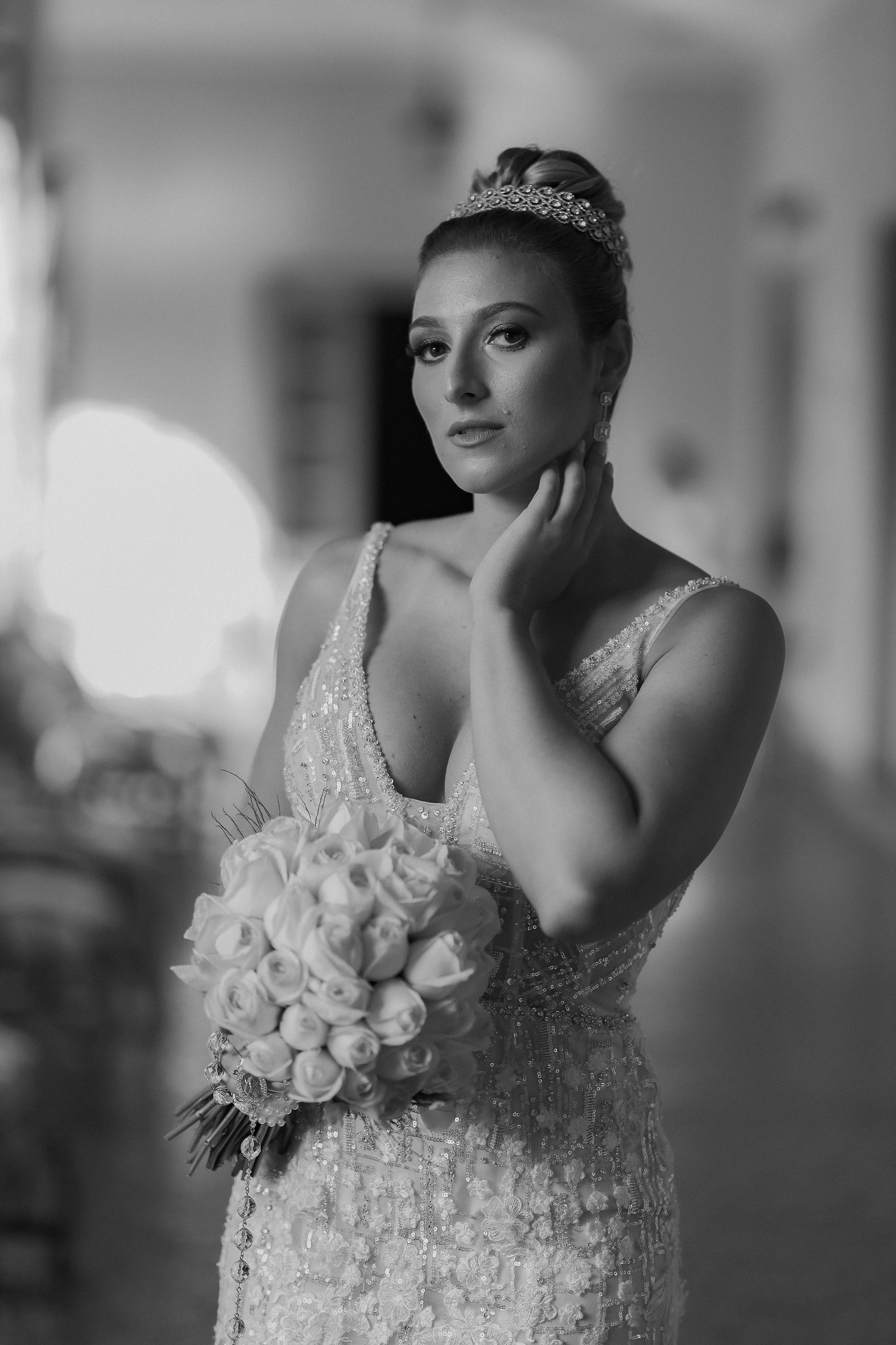 Stunning black and white portrait of a bride holding a bouquet in a wedding dress.
