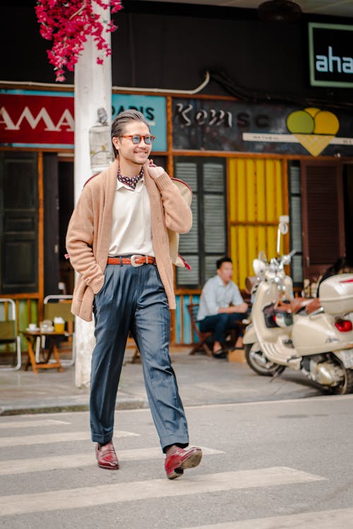 Man in Brown Cardigan and Navy Blue Pants Crossing a Street
