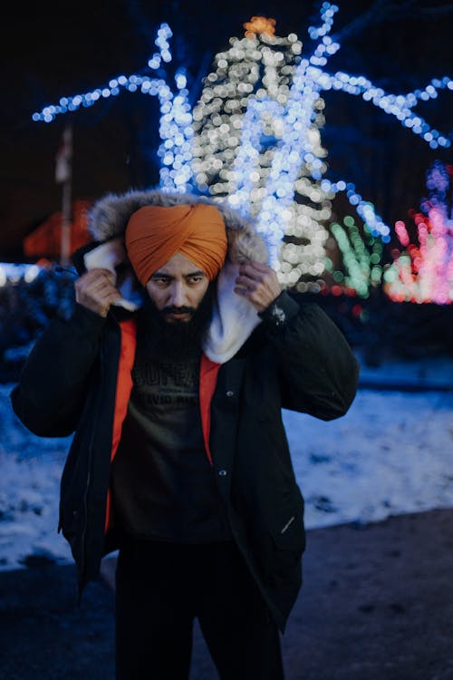 Man in an Orange Turban with Light Decorations in the Background