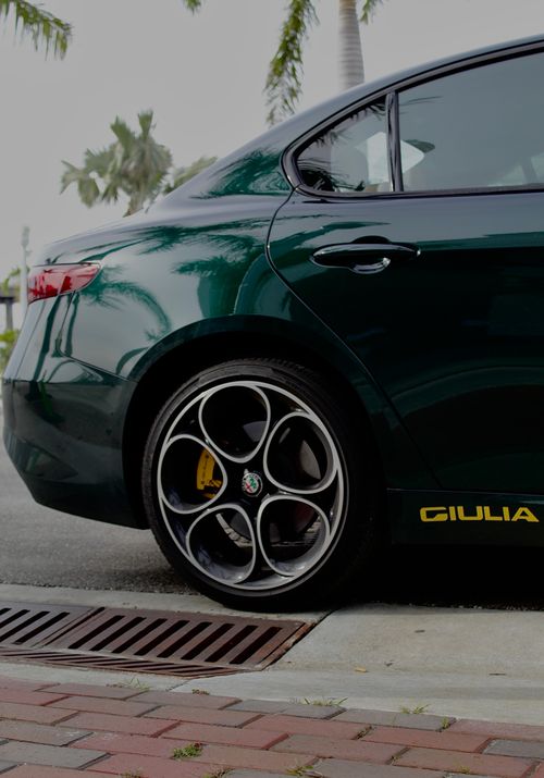 Free Rear view of an Alfa Romeo Giulia parked outdoors showcasing its alloy wheels and sleek design. Stock Photo