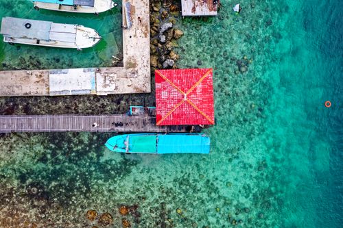 Free A stunning aerial shot capturing colorful boats docked in clear blue waters of Kepulauan Seribu Utara, Indonesia. Stock Photo