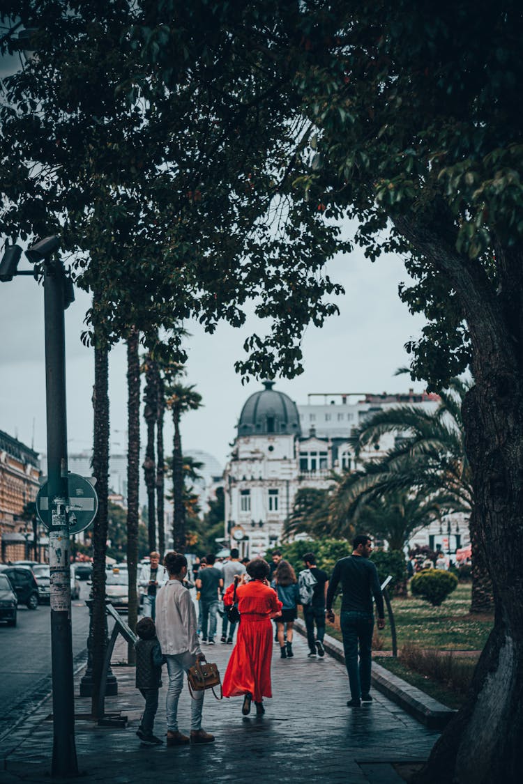 Pedestrians Walking Along A Sidewalk