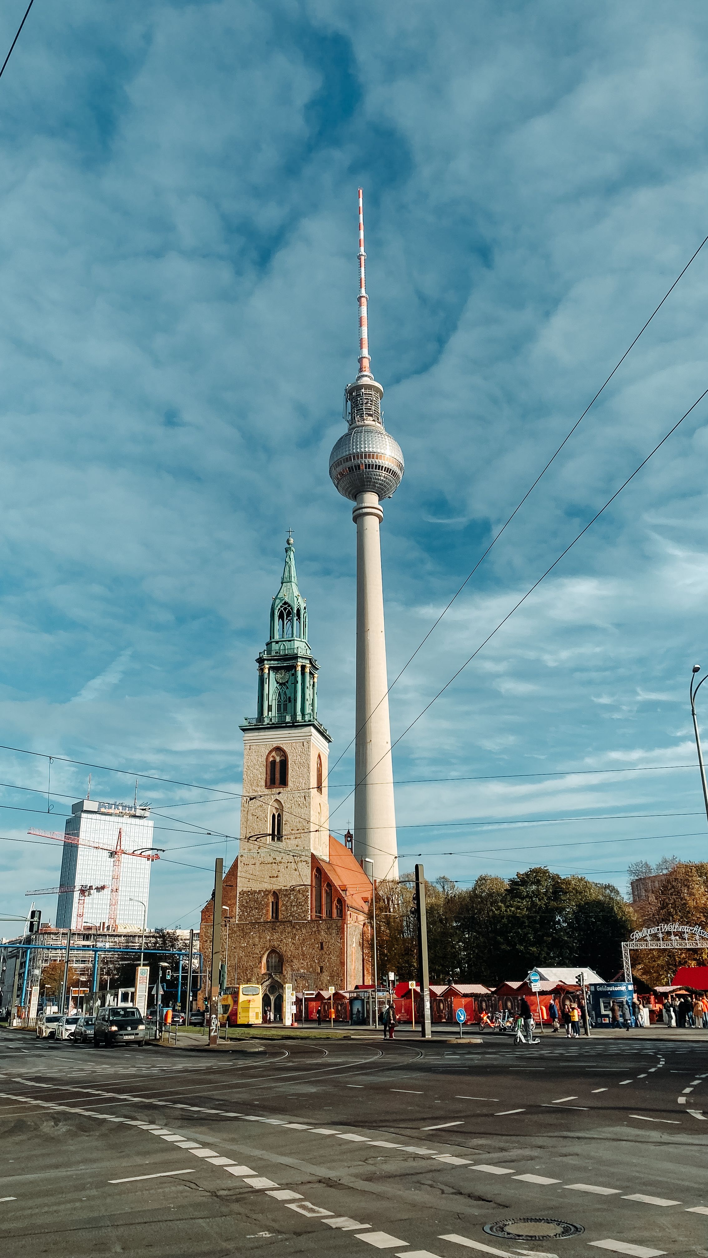 Iconic view of Berlin's TV Tower and St. Mary's Church under a clear sky.