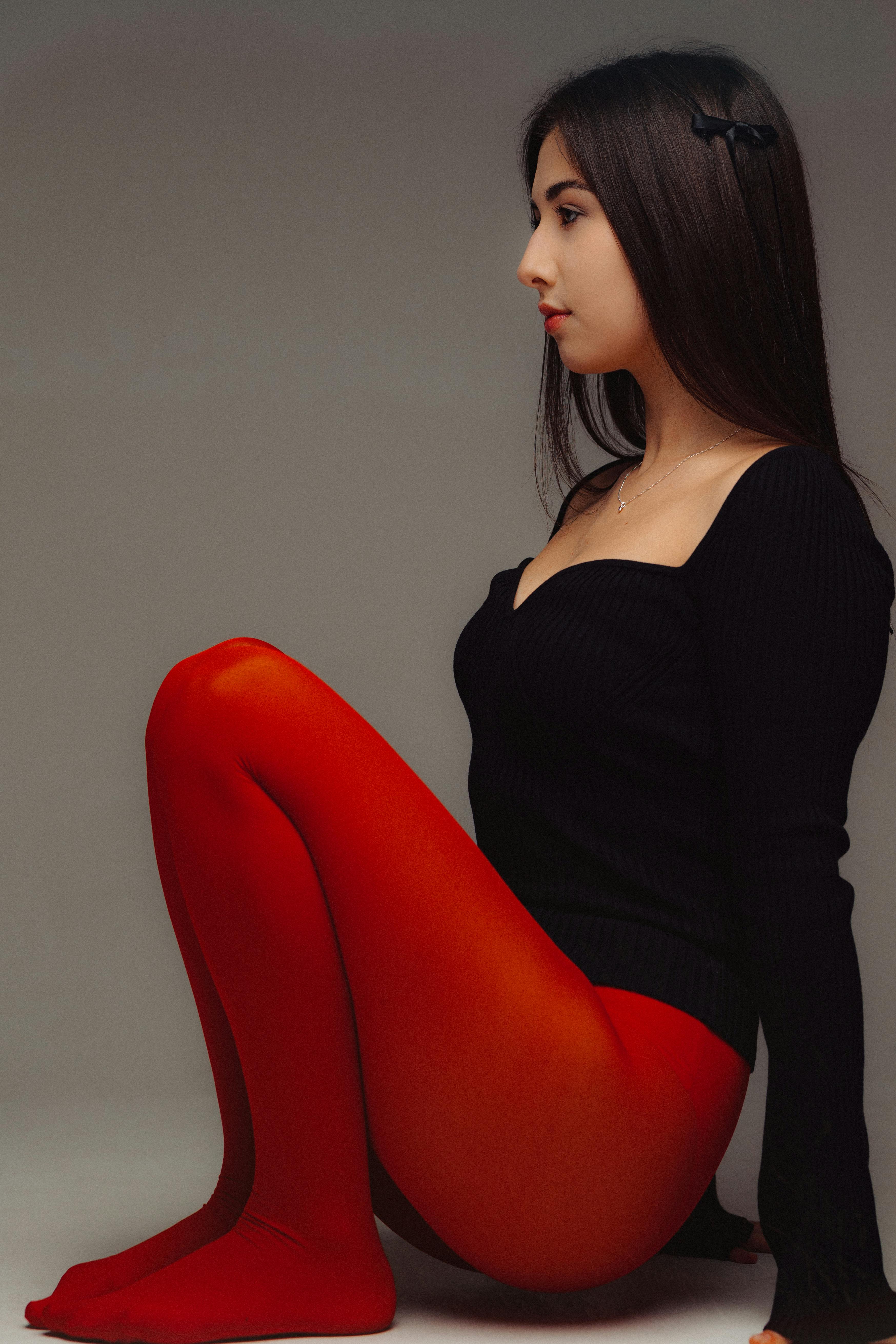 A young woman with dark hair and wearing bright red tights adopts a fashion  pose Stock Photo - Alamy