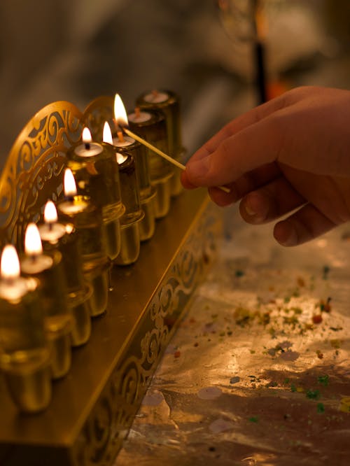 Person Lighting Traditional Candles