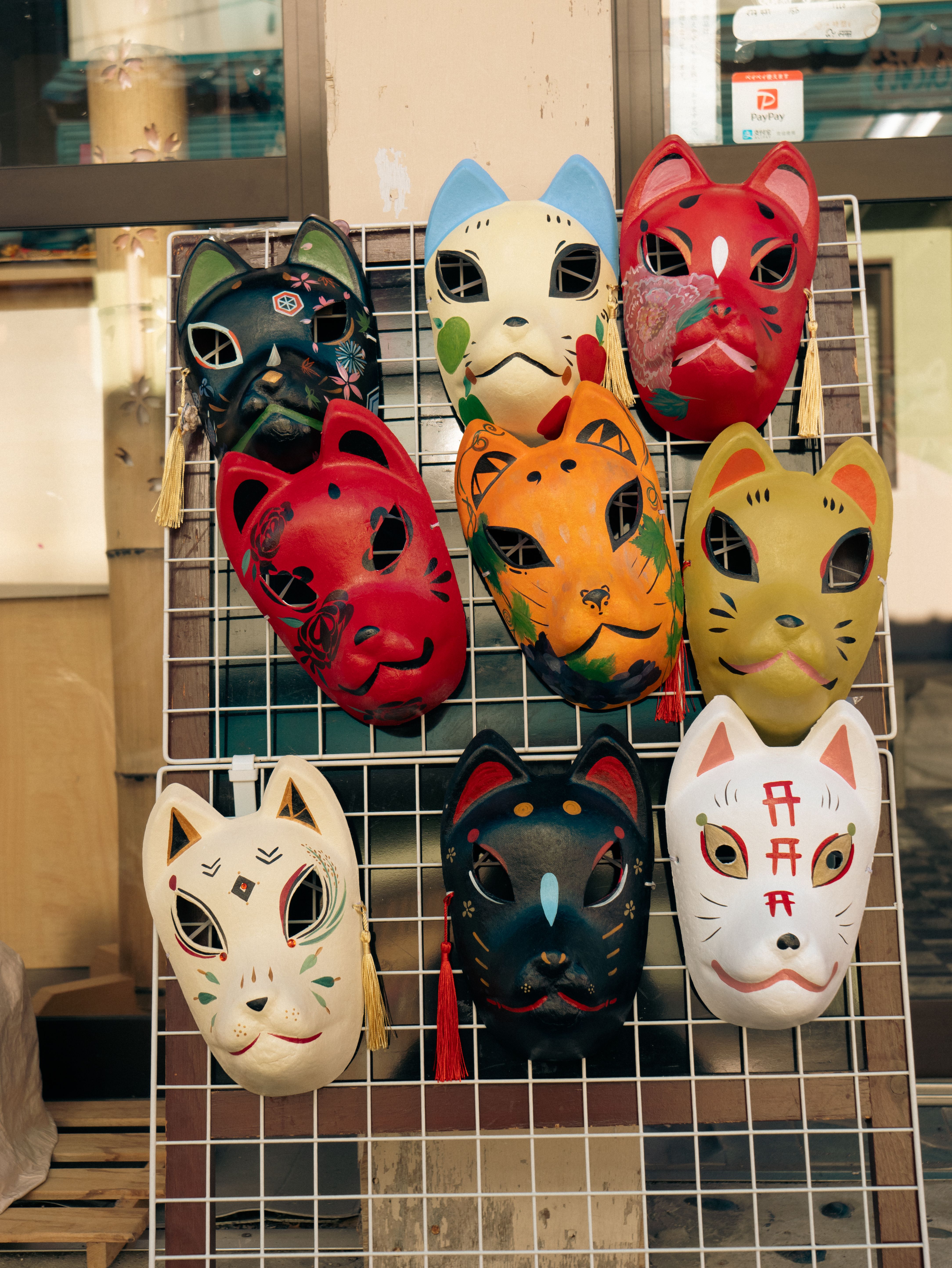 Japanese Masks for Sale Hanging on a Fence · Free Stock Photo