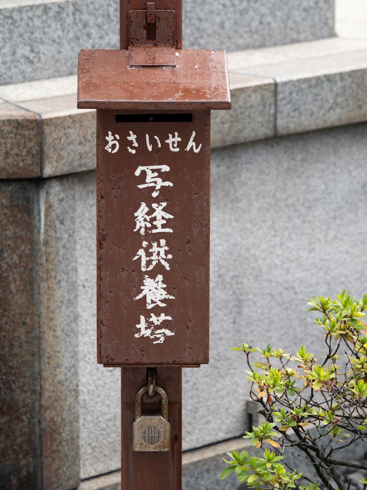 Close-up Of An Old, Rusty Mailbox With Japanese Signs 