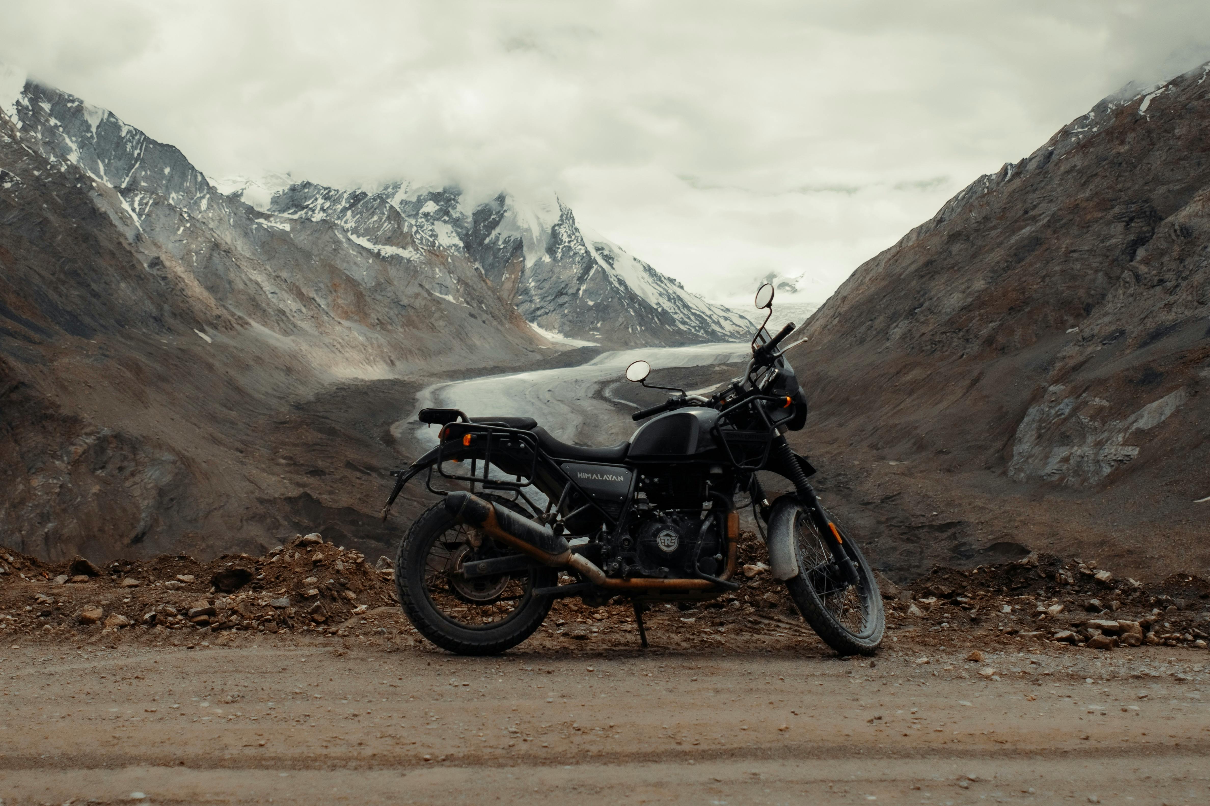 Motorcycle parked on a scenic dirt road in the Himalayas, India, perfect for adventure enthusiasts.