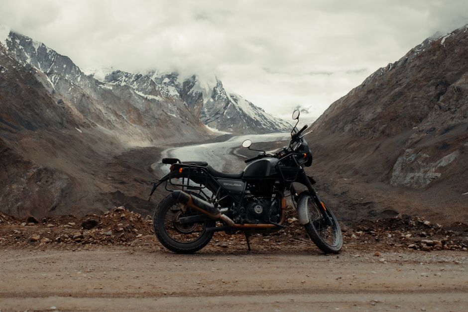 Motorcycle parked on a scenic dirt road in the Himalayas, India, perfect for adventure enthusiasts.